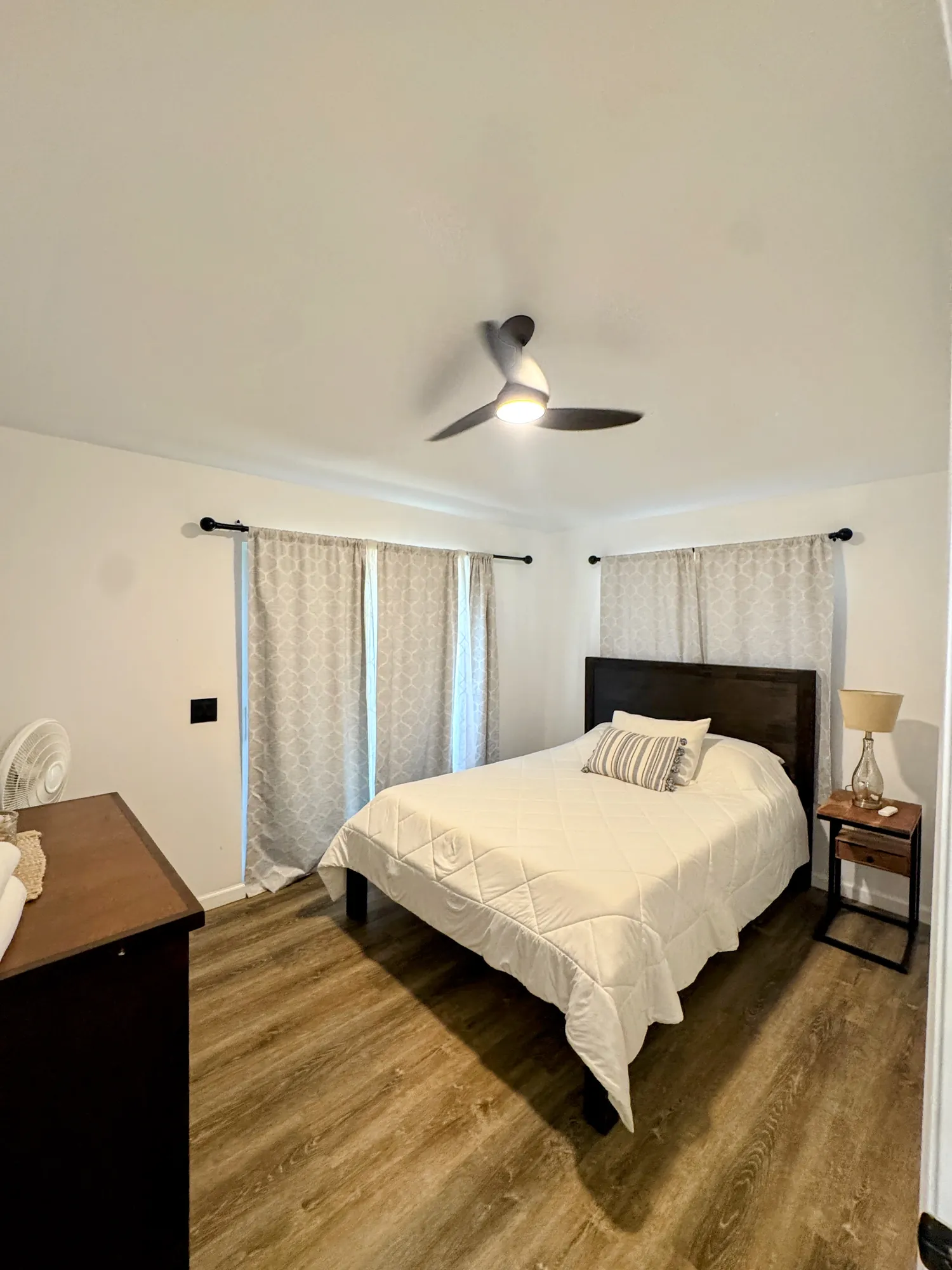 A bedroom with nightstand lamps on both sides of the bed and a dresser